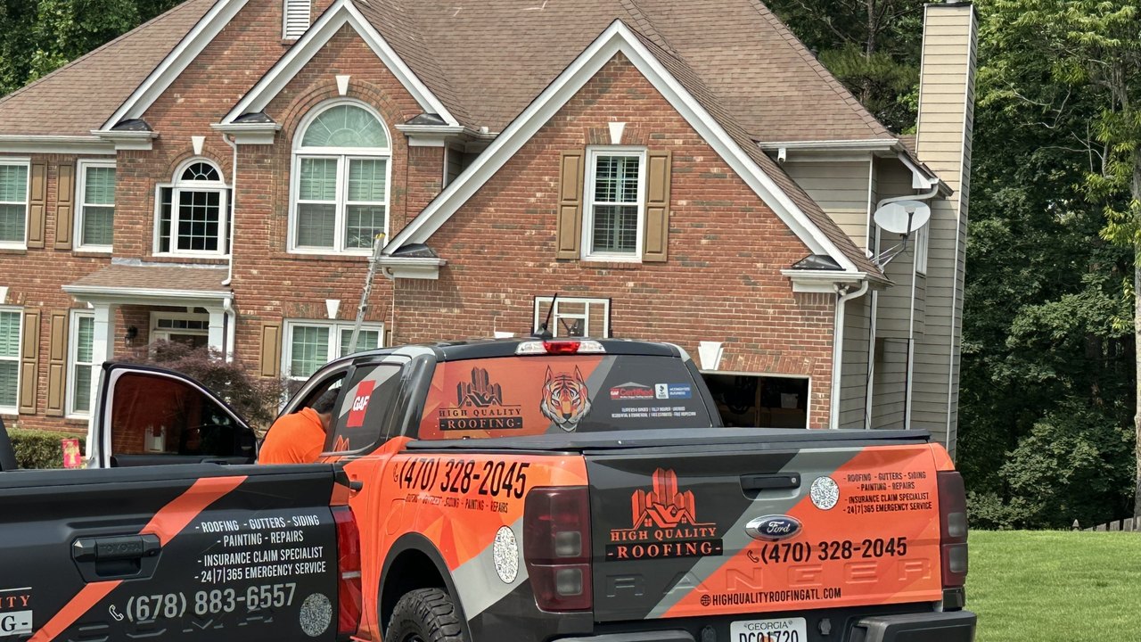 High Quality Roofing truck in front of a completed Atlanta home